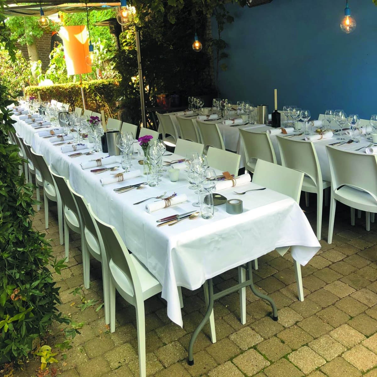 Lange gedekte tafels klaar voor een diner